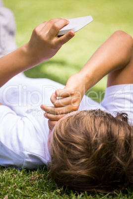A kid is lying with a mobile phone