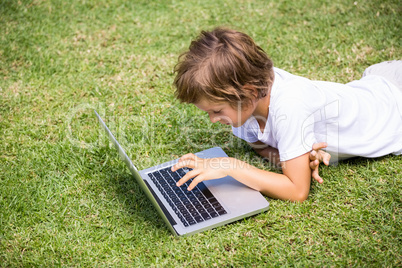Child lying using a laptop