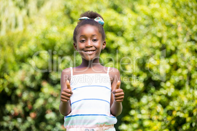 Mixed-race girl smiling and throwing up thumbs