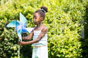 Cute mixed-race girl playing with a windmill