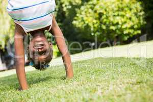 Portrait of a cute mixed-race girl smiling and doing a headstand