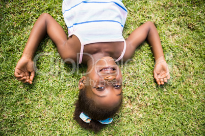 Portrait of a cute mixed-race smiling and lying on grass