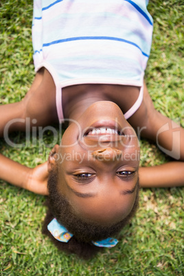 Portrait of a cute mixed-race smiling and lying on grass