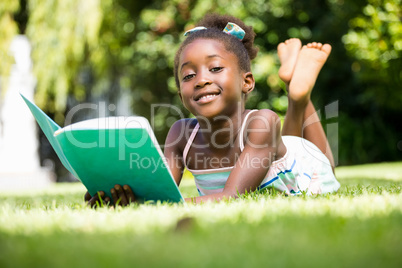 Smiling mixed-race girl lying and holding a book