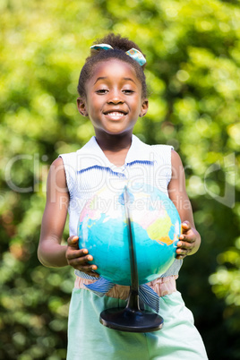 Cute mixed-race girl smiling and holding a globe