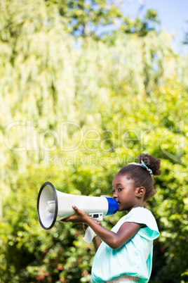 Cute mixed-race girl speaking on a megaphone