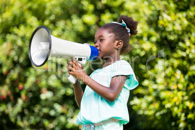 Cute mixed-race girl speaking on a megaphone