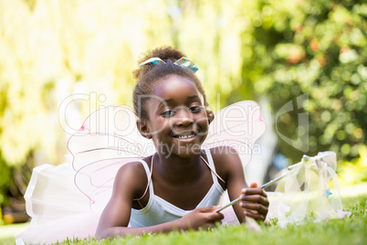 Cute mixed-race girl lying wearing a fairy dress