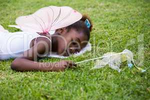 Cute mixed-race girl wearing a fairy dress and sleeping on grass