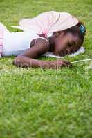 Cute mixed-race girl wearing a fairy dress and sleeping on grass