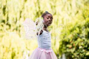 Cute mixed-race girl wearing a fairy dress and pointing the came