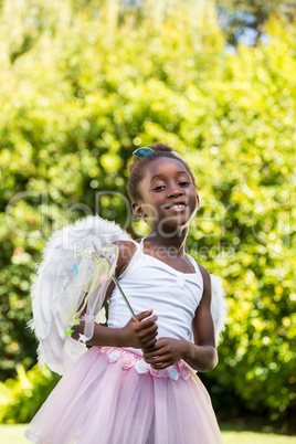 Cute mixed-race girl smiling and posing with a fairy dress
