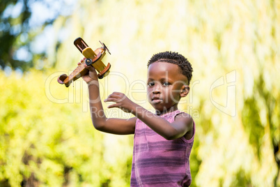 Cute mixed-race boy playing with a little plane