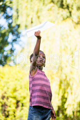Cute mixed-race boy playing with a paper plane