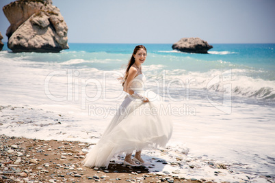 outdoor portrait of young beautiful woman bride in wedding dress on beach. Petra tou Romiou - Aphrodite's Rock.