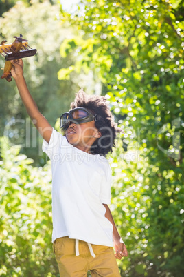 Boy playing with a toy plane at park