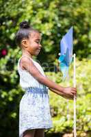 Little girl holding a pinwheel at park