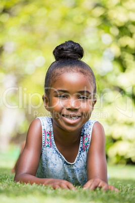 Smiling little girl laying at park