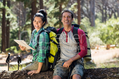 Couple smiling and sitting on a tree