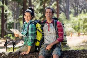 Couple smiling and sitting on a tree