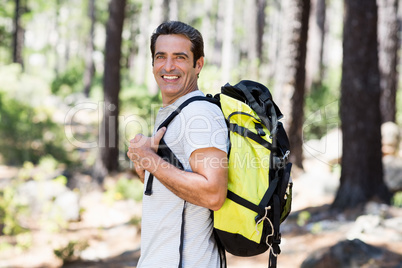 Man smiling and posing with his backpack