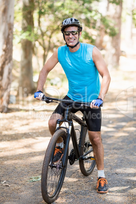 Man smiling and posing with his bike