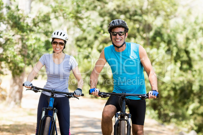 Couple smiling and posing with their bikes