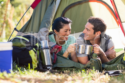Couple laying and clinking cup