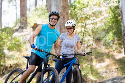 Couple smiling and posing with their bikes