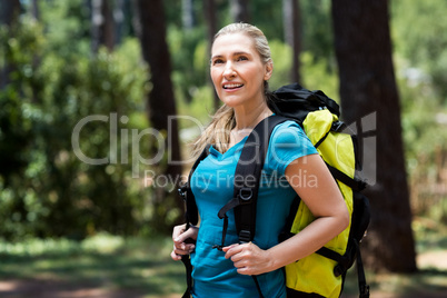Woman looking up and posing with a backpack