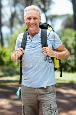 Man smiling and posing with his backpack