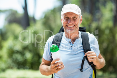 Portrait of a man smiling and holding a flask