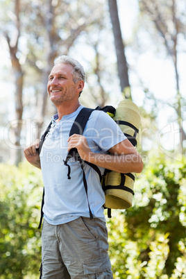 Man smiling and posing with his backpack