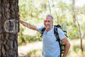 Hiker smiling and posing against a tree