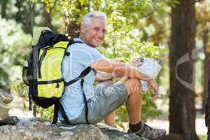 Hiker smiling and sitting on a rock