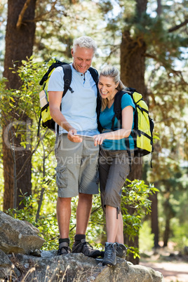 Couple smiling and looking their smartphone