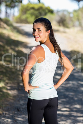 Woman runner front the back smiling and turning around to the ca