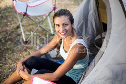 Woman smiling and sitting on a tent