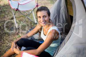 Woman smiling and sitting on a tent