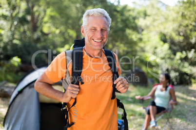 Man smiling and posing with his backpack