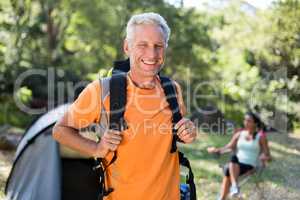 Man smiling and posing with his backpack