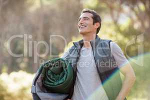 Man smiling and holding a sleeping bag