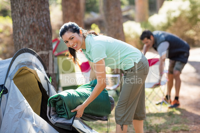 Woman smiling and holding a sleeping bag