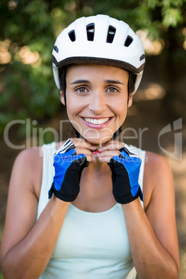 Woman smiling and fastening her cycling helmet