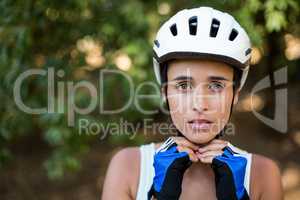 Woman fastening her cycling helmet