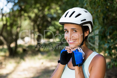 Woman smiling and fastening her cycling helmet