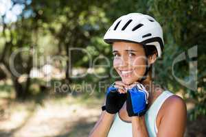 Woman smiling and fastening her cycling helmet