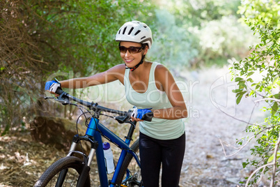 Woman smiling and walking with her bike