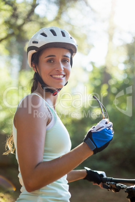 Portrait of a woman smiling and posing with her bike