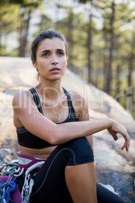 Woman sitting and posing with climbing equipment
